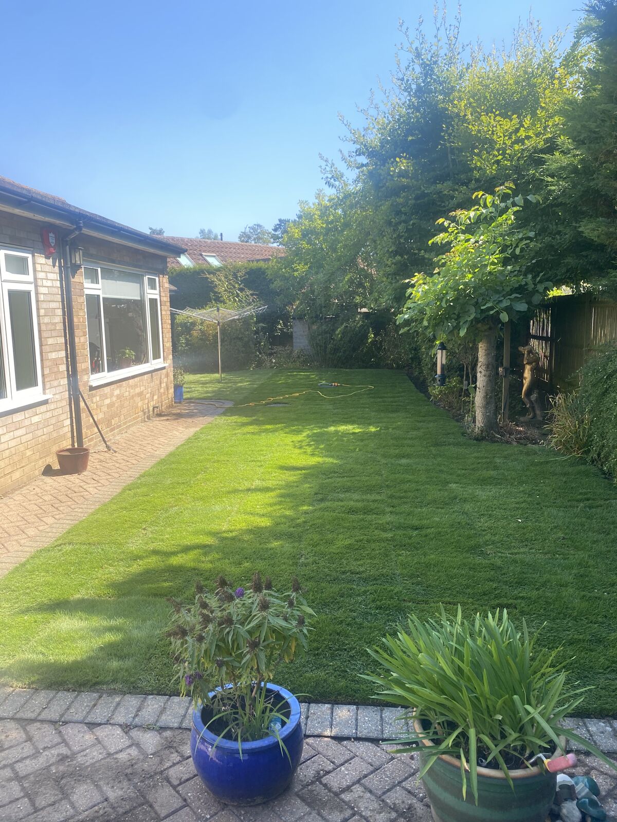 The same bungalow garden finished with a fresh green lawn running alongside the house