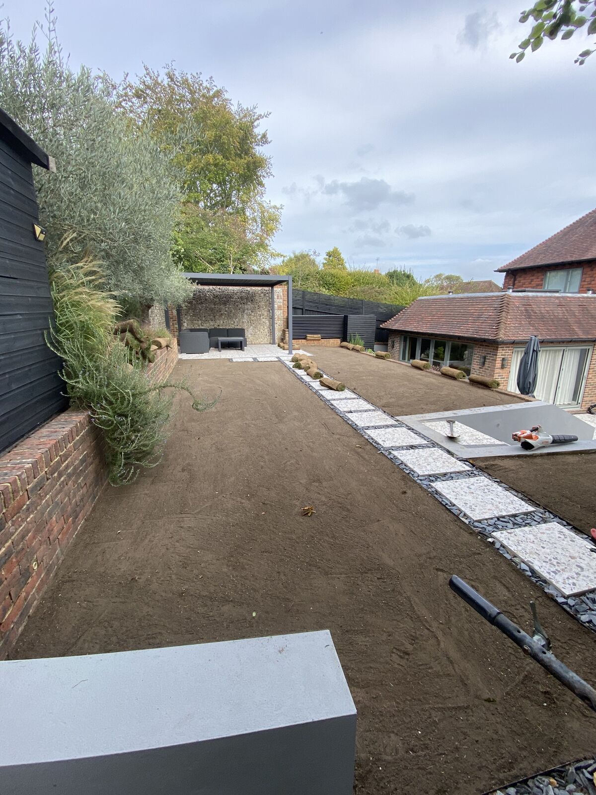Long garden prepared with fresh topsoil alongside a new stepping stone path, ready for turfing